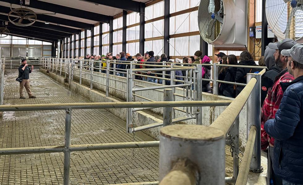 Luke Luchterhand, co-owner of Elusive Hill Dairy, describes the farm’s gate system, footbath and herd health monitoring system to participants at the 49th Annual Farm Tour.