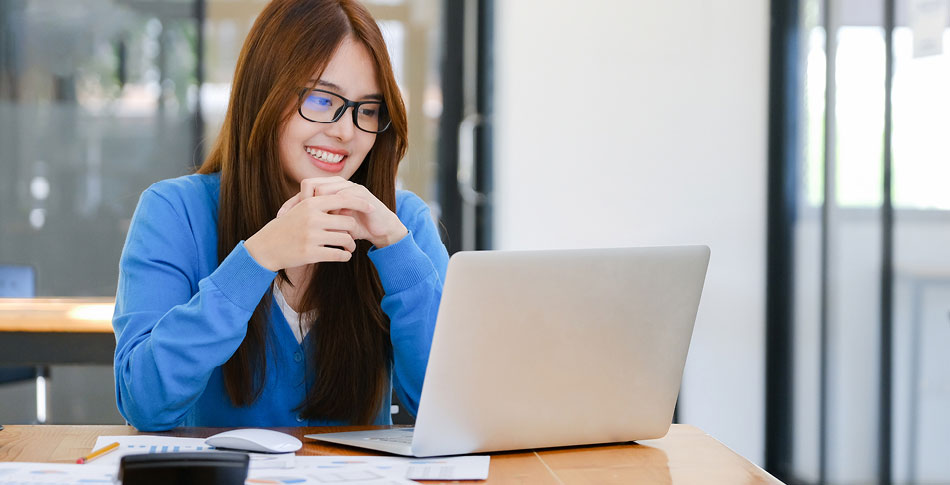 Woman looks down at her laptop.