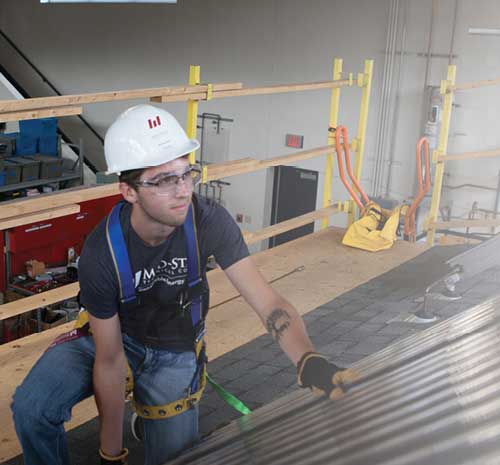 Person with Mid-State safety hat on working on roofing