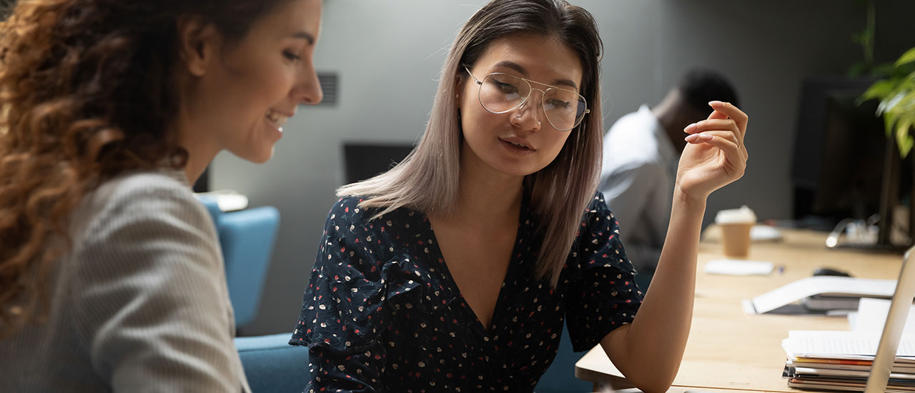 An adviser and student talking at a table