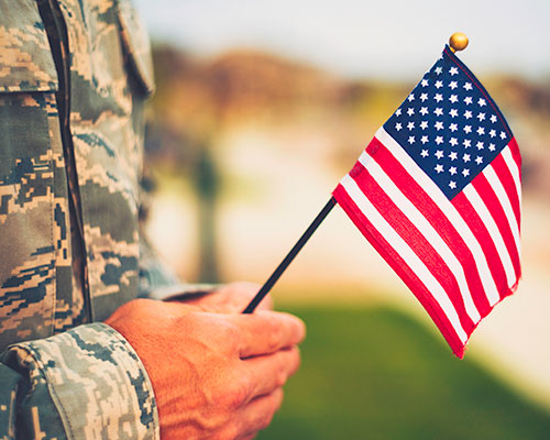 Person in uniform holding a small American flag