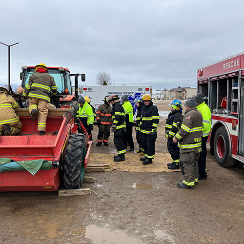 Firefighters working on farm equipment