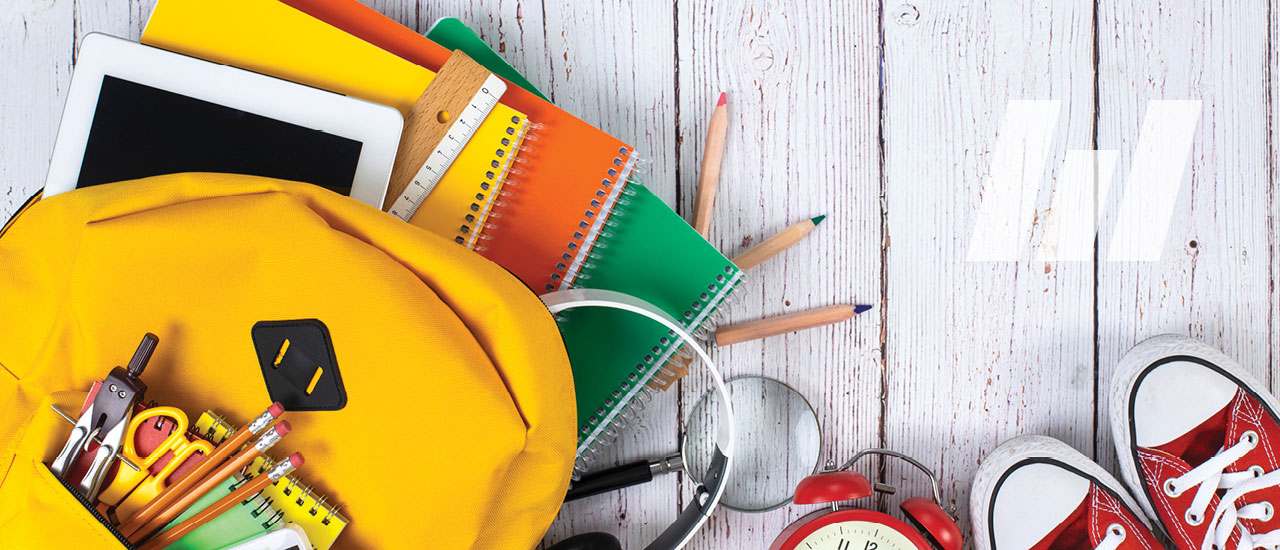 School backpack and school supplies on wooden background