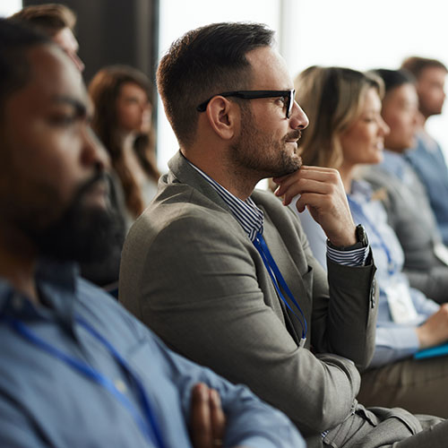 People sitting in a row dressed in professional clothing.