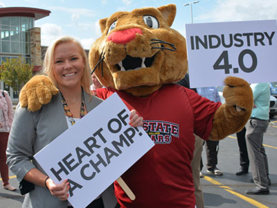 Mid-State Mascot Grit holding a sign that says "Industry 4.0". Standing next to Alex Lendved