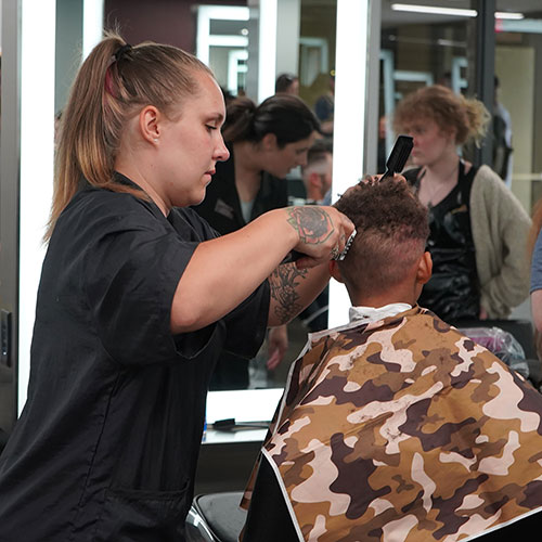 A Mid-State Technical College Cosmetology student gives a haircut to a 2023 Rafters Meet-and-Greet & Cuts 4 Kids event attendee on the Wisconsin Rapids Campus.