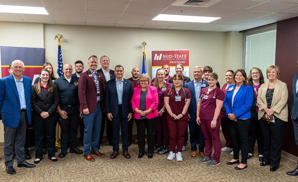 Mid-State Technical College’s president, Dr. Shelly Mondeik, front/center, with HHS Secretary Xavier Becerra, to her right, during the Secretary’s visit to the College’s Healthcare Simulation Center in Wisconsin Rapids, Wis., June 13. They are joined by Mid-State students, leadership and partners including leadership from Aspirus and Legacy Foundation of Central Wisconsin. 