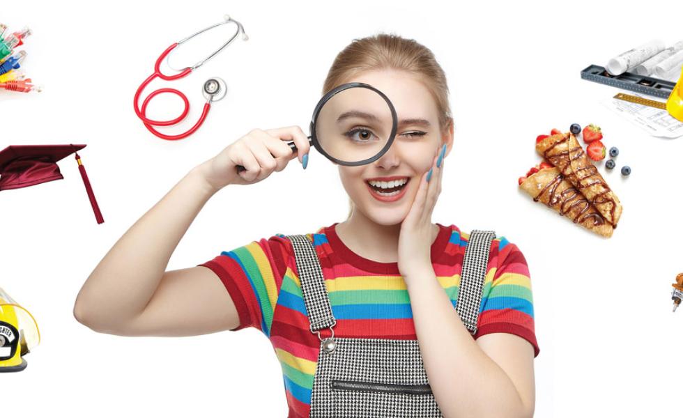 Person looking through a magnifying glass with a stethoscope, cables, pastry, graduation cap, and robotic arm surrounding them.