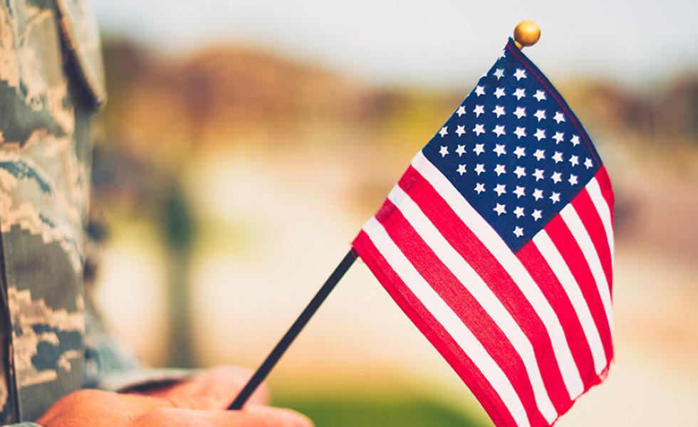 Service member holding an American flag.