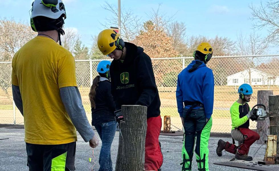 Tree Tech attendees practice creating notches in trees while utilizing safe chainsaw techniques in the outdoor chainsaw training facility at Mid-State Technical College’s Wisconsin Rapids Campus on Nov. 15.