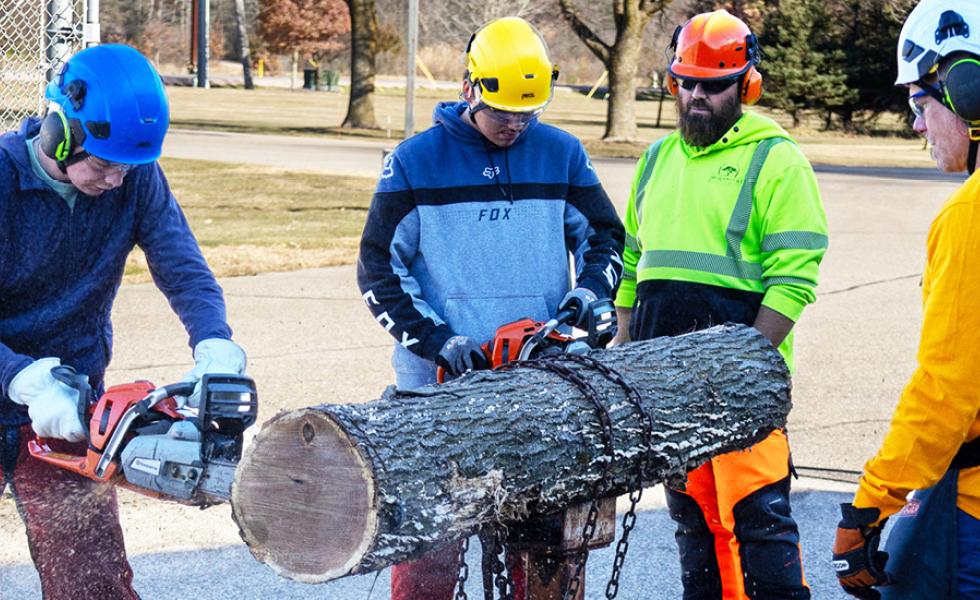 Tree Tech 2025 participants get chainsaw training by arboriculture professionals at the Wisconsin Rapids Campus.
