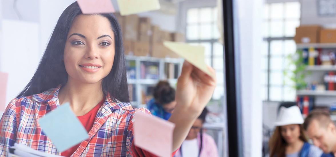 Woman in flannel shirt throwing paper airplane