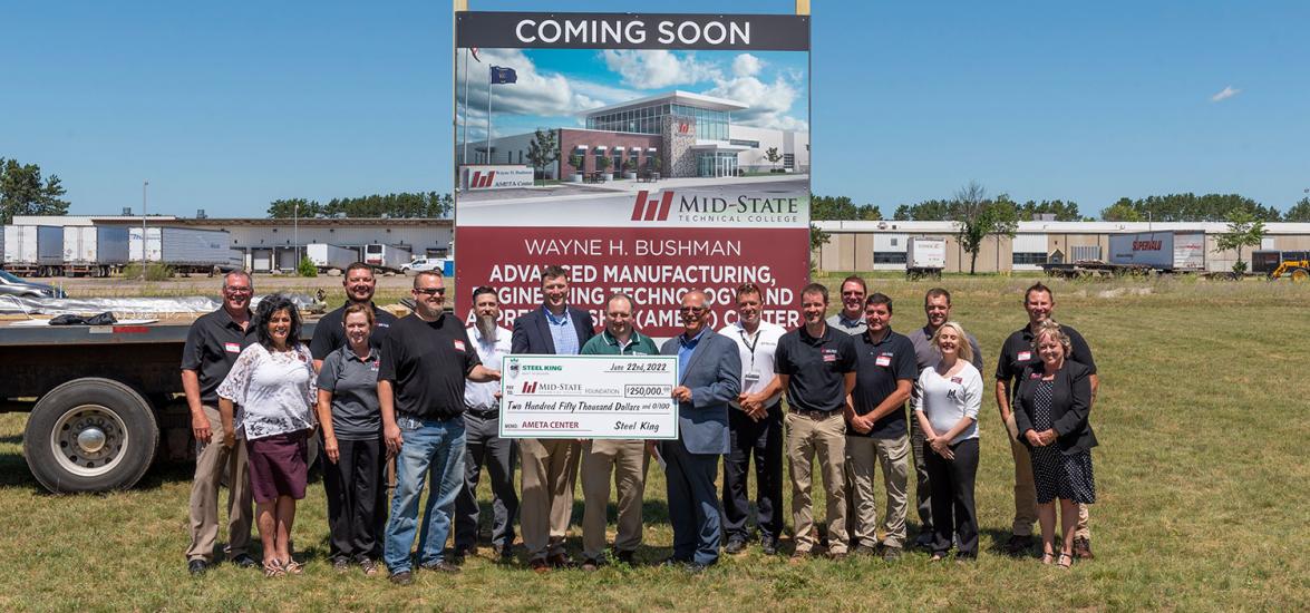 Front and center, current Steel King President Jay Anderson and President-Elect Brian Pfannes present the Mid-State Advanced Manufacturing Engineering Technology and Apprenticeship (AMETA) campaign team and faculty $250,000 for sponsorship of a new state-of-the-art Welding Lab during the recent AMETA site dedication event in Stevens Point. (Photo by Jessica Kopecky Design)