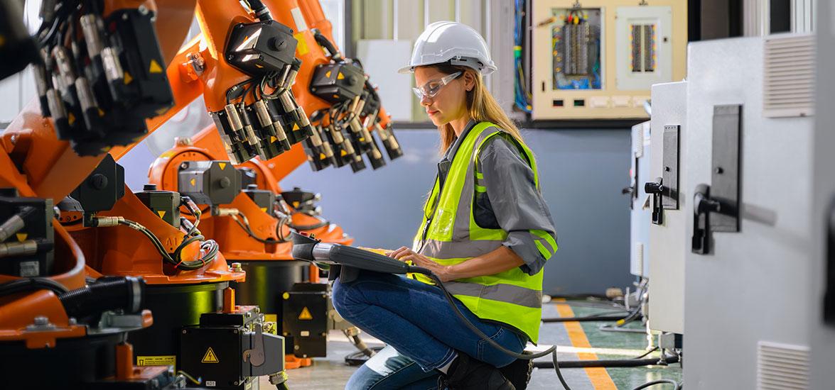 Student working with high-tech equipment wearing protective gear.