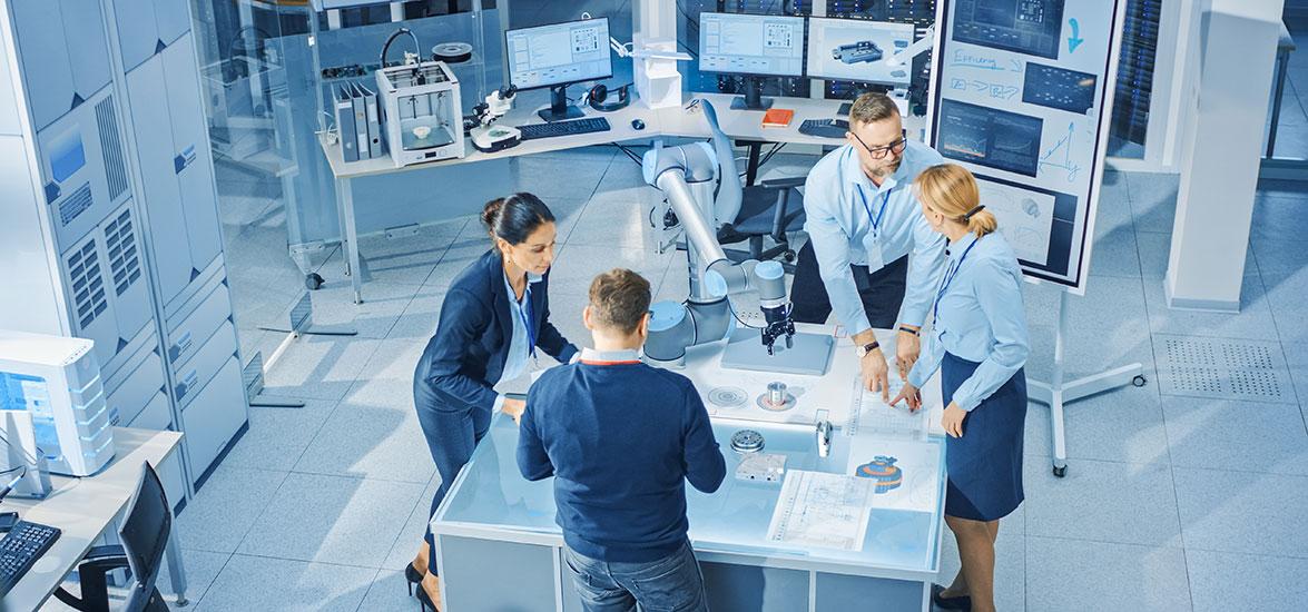 People working at a table on mechanical designs.