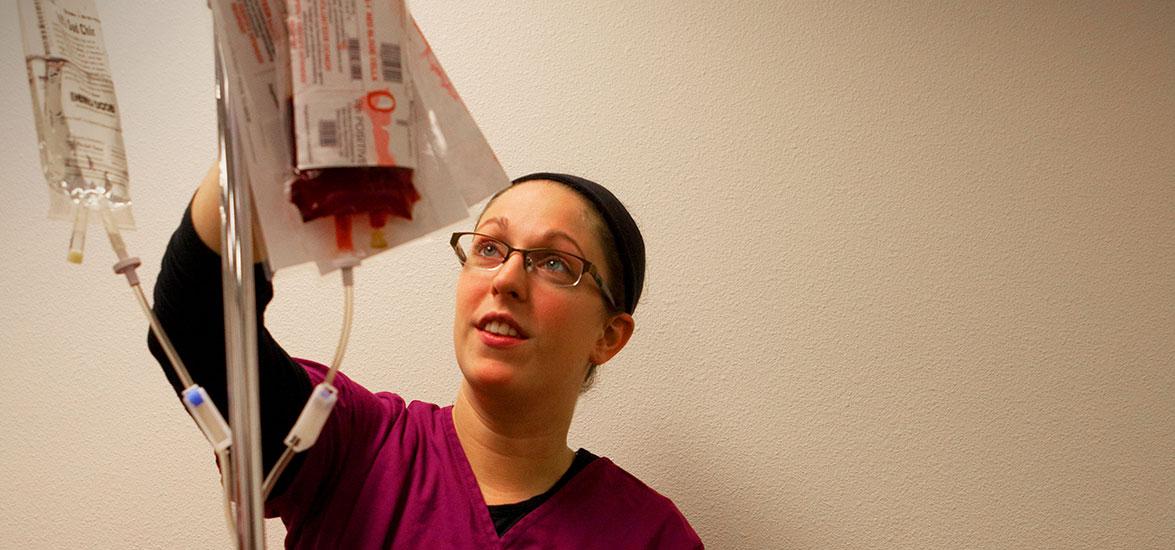 Mid-State Nursing student sets up an IV.