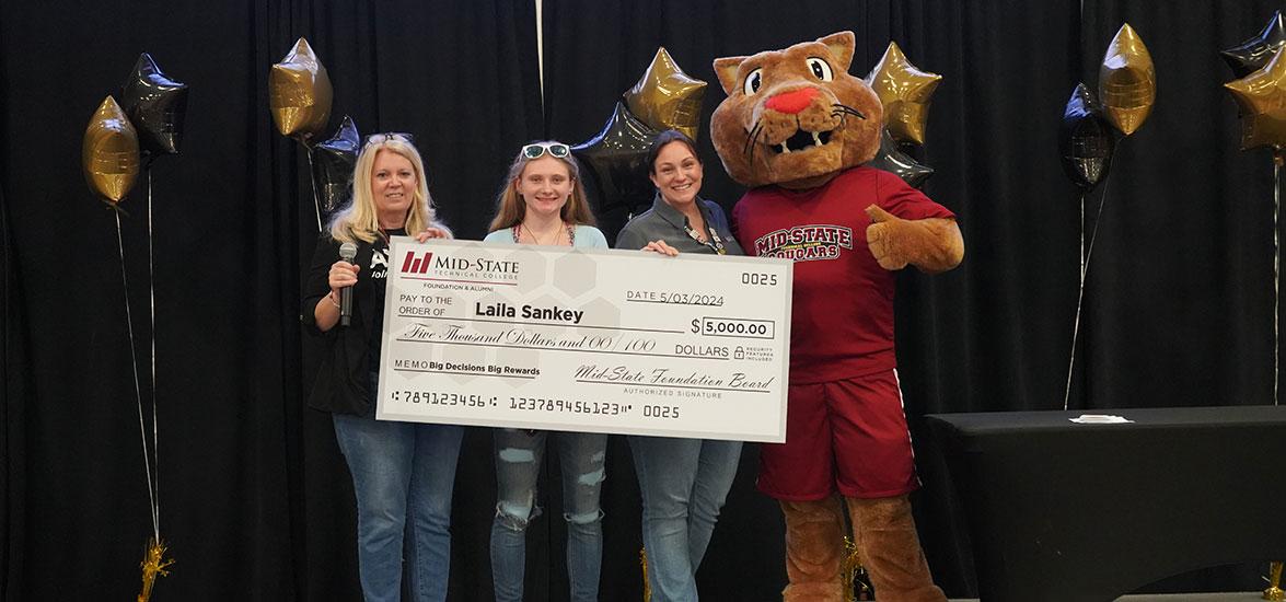 Laila Sankey, Pittsville High School graduating senior, receives Mid-State’s $5,000 Big Decision Scholarship. From left: Micki Dirks-Luebbe, Foundation & Alumni director; Laila Sankey; Nikki Dhein, donor relations manager; and Grit, Mid-State’s cougar mascot.