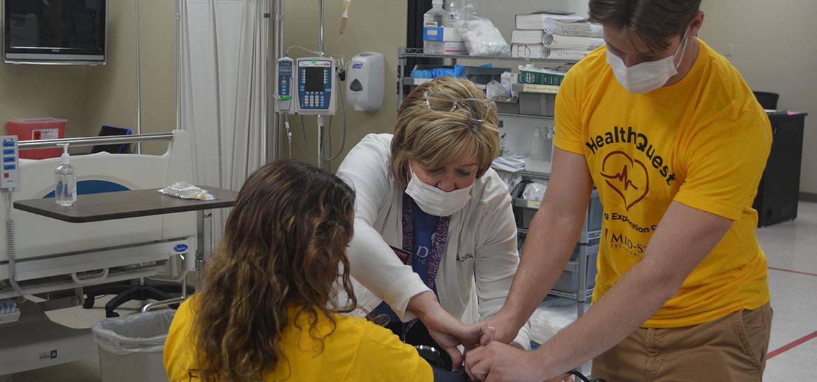 Mid-State Technical College Dean of the School of Nursing, Deb Johnson-Schuh, assists two HealthQuest: Nursing Exploration Camp attendees while they practice taking blood pressure measurements during the June 10 camp on the Wisconsin Rapids Campus.