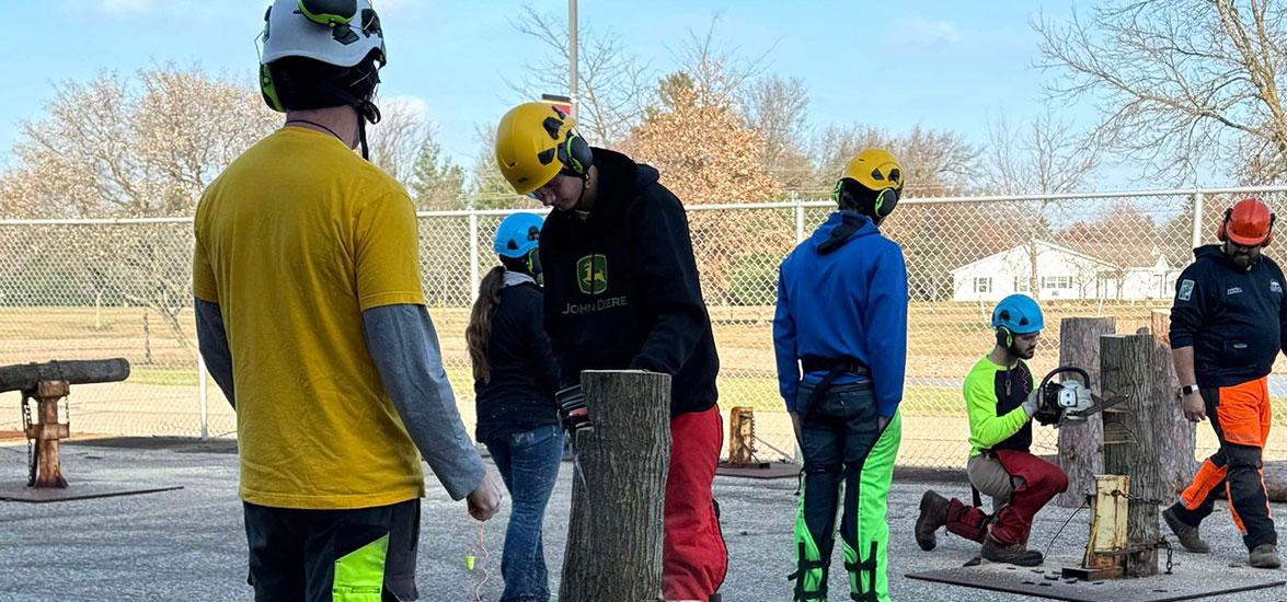 Tree Tech attendees practice creating notches in trees while utilizing safe chainsaw techniques in the outdoor chainsaw training facility at Mid-State Technical College’s Wisconsin Rapids Campus on Nov. 15.