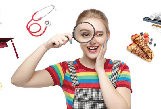 Person looking through a magnifying glass with a stethoscope, cables, pastry, graduation cap, and robotic arm surrounding them.