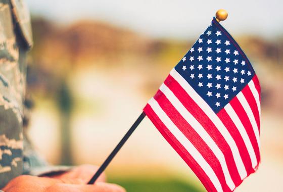 Service member holding an American flag.