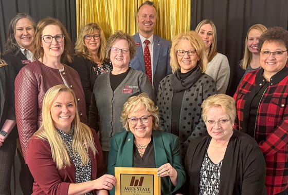 Mid-State Technical College was presented with the Marshfield Area Chamber of Commerce and Industry award at MACCI’s Annual Dinner on Wednesday, January 29, in Marshfield, Wis. Pictured, front row, are Dr. Alex Lendved, Mid-State dean of the Marshfield Campus and School of Applied Technology; Dr. Shelly Mondeik, Mid-State president; and Betty Bruski-Mallek, Mid-State Board of Directors member. They are surrounded by Mid-State staff. 